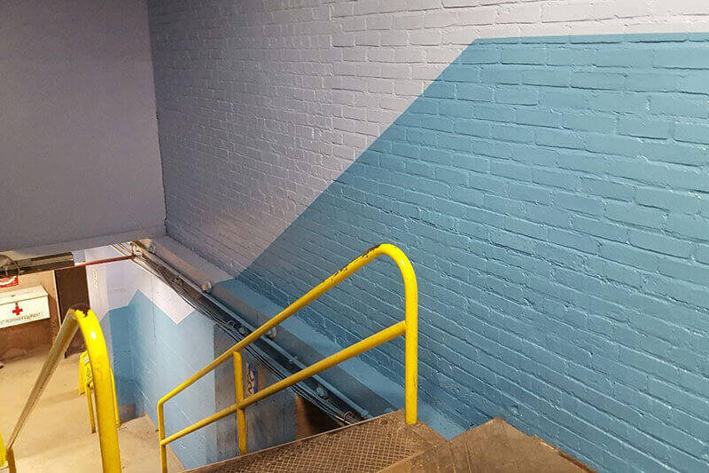 Industrial interior painting safety yellow stair railing. Schwaller's Painting, Staining & Drywall.
